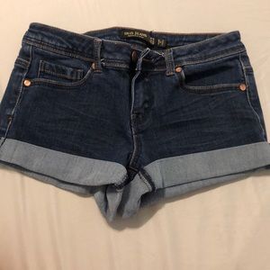 Medium Dark washed rolled jean shorts.